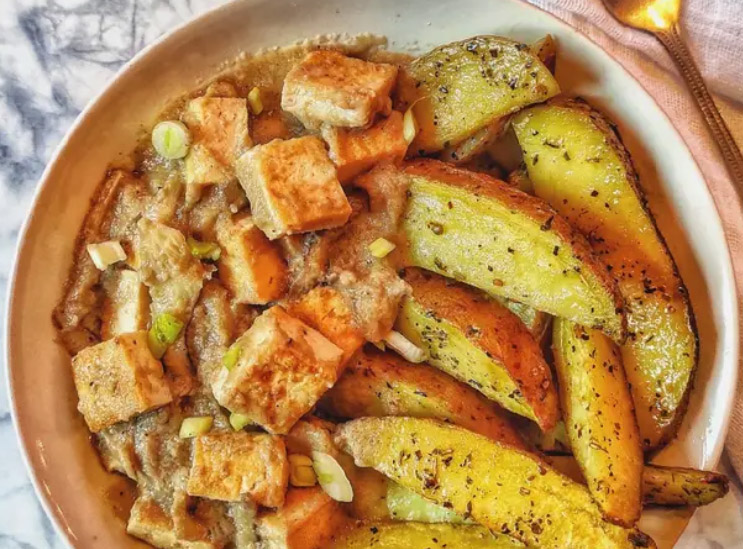 Imagen ilustrativa de tofu al curry con papas asadas.